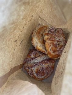 two cinnamon buns in a brown paper bag