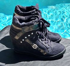 "Vintage Guess black faux suede, faux leather, and patent leather hightop wedge athletic shoes, with a velcro closure, and silver studs. These also have a metal and rhinestone Guess logo on the side. These Badass hightops😎 have 7 eyelets , so the upper is the height of a hightop tennis shoe, with a 3\" inch covered wedge.  They have rubber bottoms just like an athletic shoe, and the toe shape is like an athletic style shoe, like a squared off round toe shape. ✨️These vintage Guess wedges are in Excellent \"barely used\" vintage condition. Size 9 Thanks, Enjoy! #badass #shoes #y2k #vintage #gift #guess #wedges #bikerchick #goth #punk #rocker #gothic #platforms #hightops" Trendy High-top Wedge Sneakers With Studded Outsoles, Trendy High-top Suede Platform Sneakers, Gothic Platforms, 2000s Shoes, Shoes Y2k, Platform Tennis Shoes, Sneaker Wedges, Shoes Cool, Goth Shoes