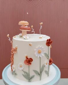 a white cake with flowers and mushrooms on it