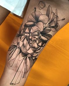 a person with a tattoo on their leg that has flowers and an elephant in it