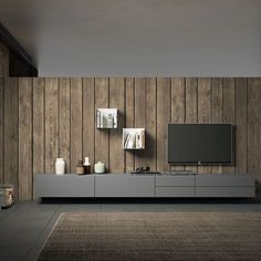 a living room with wood paneling and a flat screen tv mounted on the wall