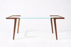 a glass table with wooden legs on a white background