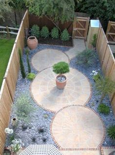 a small garden is shown in the middle of a yard with stone walkways and potted plants