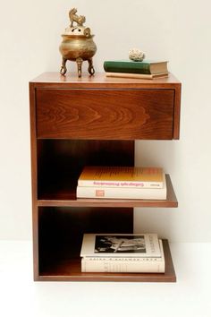 a book shelf with books and a vase on top