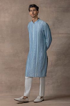 Light blue full sleeve kurta with mirror embroidery in stripe pattern and mandarin collared neckline. Paired with pant.
Components: 2
Pattern: Embroidery
Type Of Work: Mirror, stripe
Neckline: Mandarin collar
Sleeve Type: Full sleeves
Fabric: Chanderi Silk
Color: Blue
Other Details: 
Front concealed button placket
Occasion: Sangeet - Aza Fashions Light Blue Kurta Men, Kurta Designs Men's, Embroidery Mirror, Mirror Embroidery, Blue Kurta, Kurta Set For Men, Kurta Men, Mens Kurta Designs, Mens Kurta