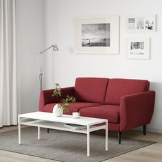 a living room with a red couch and white coffee table