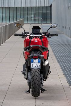 a red motorcycle parked next to a building