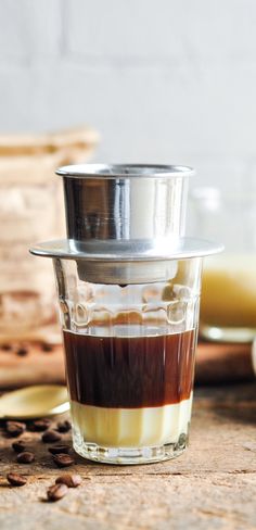 a shot glass filled with coffee sitting on top of a wooden table