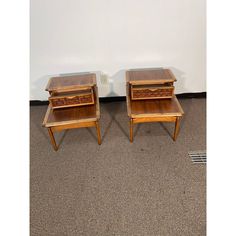 two wooden end tables sitting next to each other on top of carpeted flooring