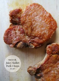 two pork chops sitting on top of a cutting board with the words juicy skillet pork chops below them