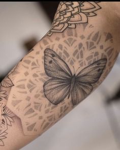 a woman's arm with a butterfly tattoo on it