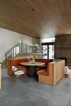 a living room filled with furniture next to a stair case on the side of a wall