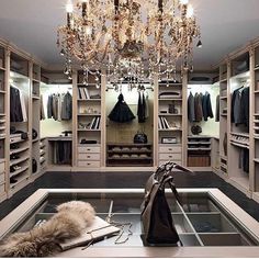 an open closet with a chandelier hanging from the ceiling