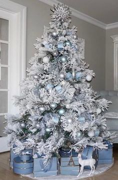 a white christmas tree with silver ornaments and tinsel