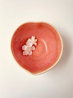 a pink bowl with white flowers in it