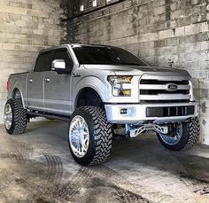 a silver truck parked in a garage next to a brick wall