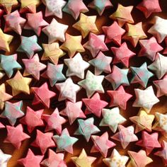 many small pink and white stars on a table