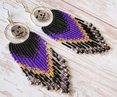 Step into the spirit of the season with these Jack-o'-lantern beaded fringe earrings, a perfect blend of Halloween charm and elegant style. Adorned with a playful Jack-o'-lantern metal charm,  beaded with a color palette of deep purple, black, and shimmering gold beads. These earrings are are 4 and 3/4 inches long and 1 1/2 inch in width. These earrings are handmade by me ❤️ 4 3/4" length 1 1/2" width Materials:  Czech glass seed beads Black and gold fire polished glass beads Black twist bugle g Halloween Hoop Earrings, Beaded Fringe Earrings, Halloween Charms, Beaded Fringe, Ear Hook, Metal Charm, Fringe Earrings, Purple Black, Chandelier Earrings