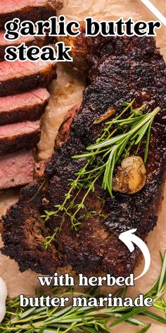 there is a steak with herbs on top and garlic on the side, along with butter marinade