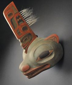 a ceramic mask with an animal's head on top of it, against a black background