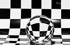 a black and white checkered wallpaper with a glass ball