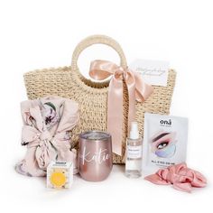 a basket filled with cosmetics and other items next to a pink ribbon tied around it