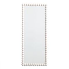 a white framed mirror with beaded edges