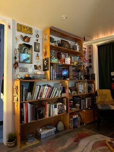 a living room filled with lots of books on top of a wooden book shelf next to a doorway