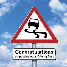 a street sign that says congratulationss on passing your driving test in front of a blue sky with clouds