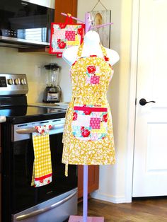 two aprons are hanging on a stand in front of an oven and stove top