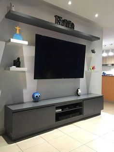 a flat screen tv mounted to the side of a wall in a room with tile flooring