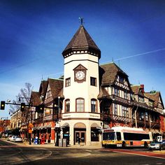 a large white building with a clock on it's face in the middle of town