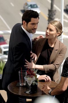 a man standing next to a woman at a table