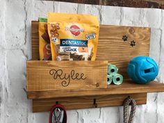 a wooden shelf with some dog treats on it and a blue ball hanging from the wall