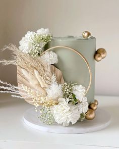 a cake decorated with white flowers and feathers