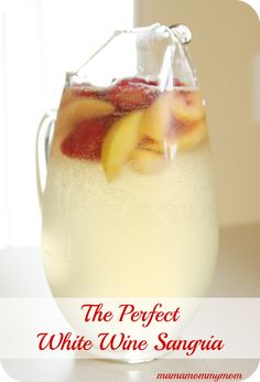 a pitcher filled with ice and fruit on top of a table