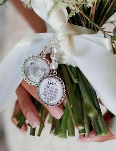 a person holding a bouquet with flowers and a keychain attached to it's wrist