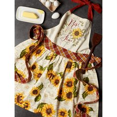 sunflowers are on the table next to an apron and baking utensils