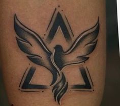 a tattoo on the leg of a person with a bird and triangle in the middle