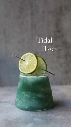 a green drink with a lime slice on top and the words tidal wave above it