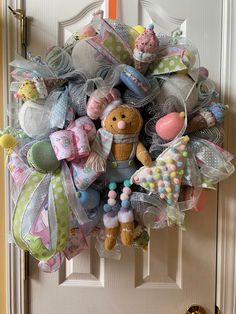 a wreath is hanging on the front door decorated with toys and decorations for children's birthdays