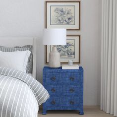 a blue dresser next to a bed with two pictures on the wall and a lamp