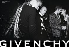 several people standing together in front of a black and white photo with the words givenchy on it