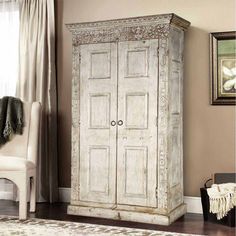 an old white armoire in a living room