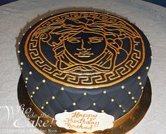 a black and gold birthday cake with the face of jesus on it's side