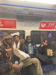 four people sitting on a subway train