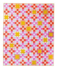 an orange and pink checkered quilt with stars on the top, in front of a white background