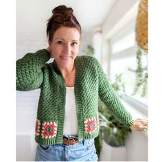 a woman wearing a green knitted cardigan and smiling