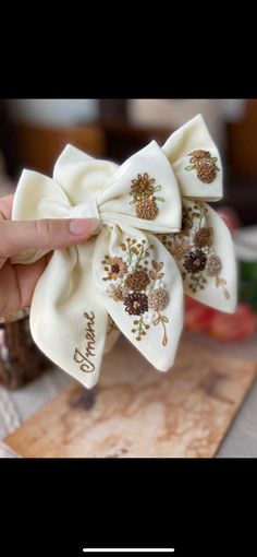 a person is holding up a white bow with flowers on it and the words happy birthday written on it