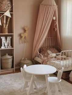 a small child's room with a bed, table and chair in the corner